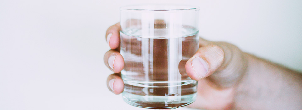 hand som håller i ett vattenglas